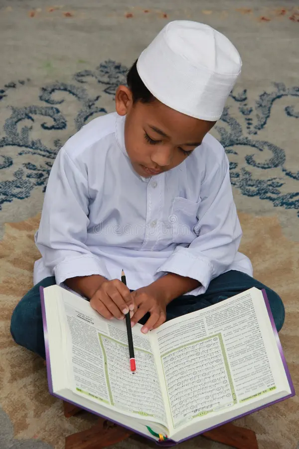 Smiling child holding Quran - Islamic education at Dugsi Qur'an